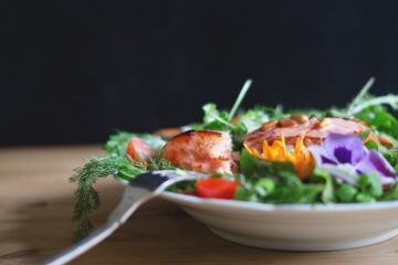 serving of salad and fish on white plate