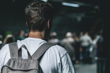 man carrying backpack standing