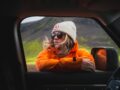 A woman in an orange jacket in a car