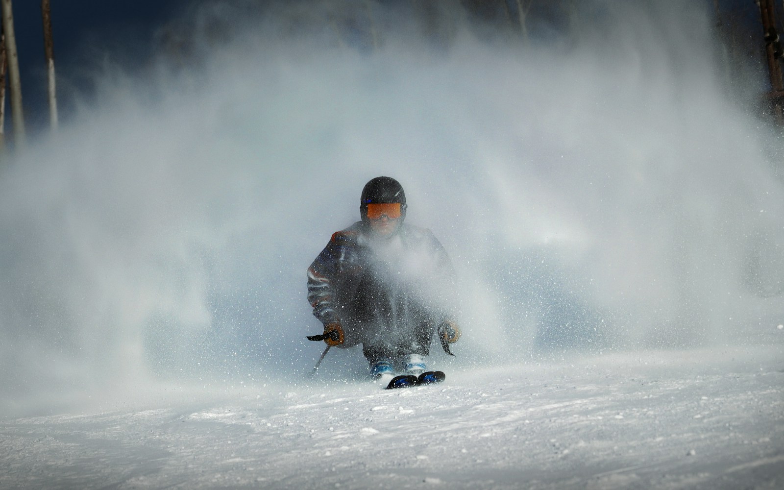 a man riding skis down a snow covered slope